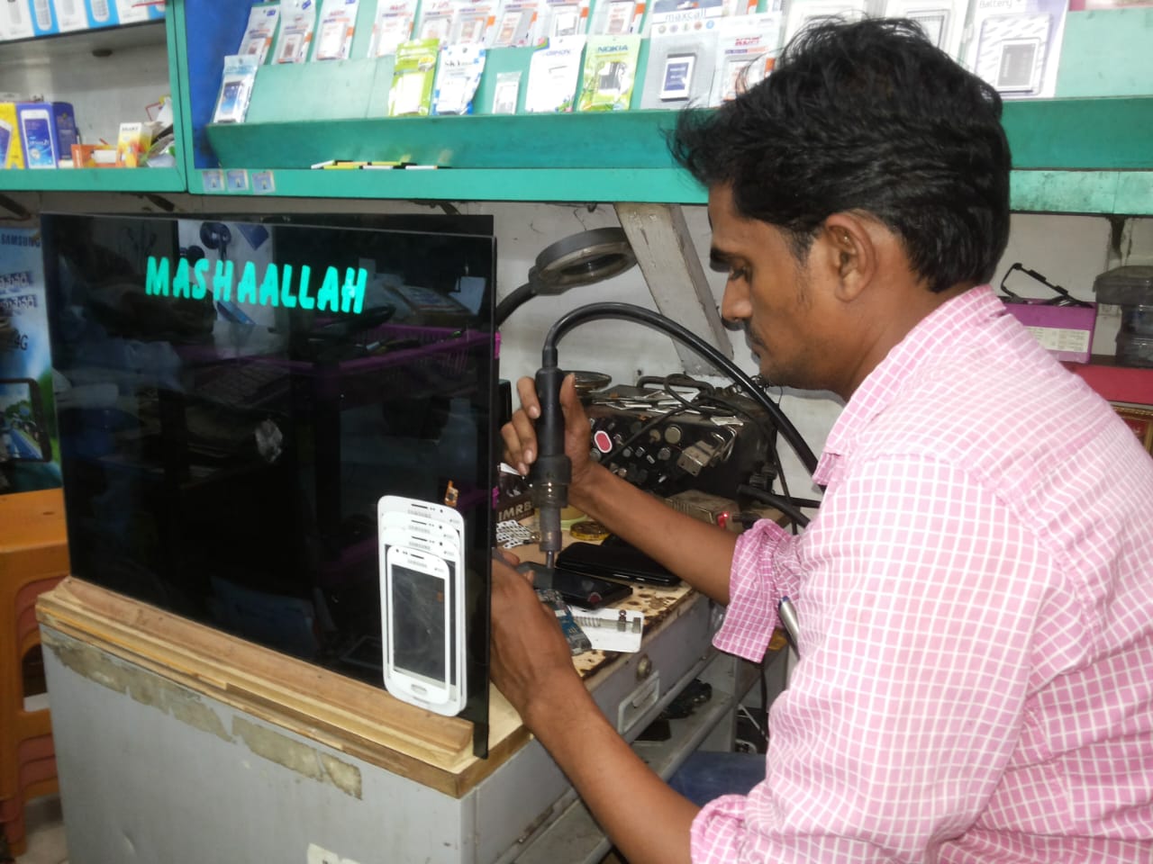 Experienced technician working on a mobile phone at BBC Mobile Service Center